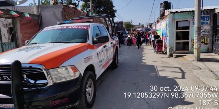 Niños disfrazados participando en el desfile "Calaverita" con elementos de seguridad pública.